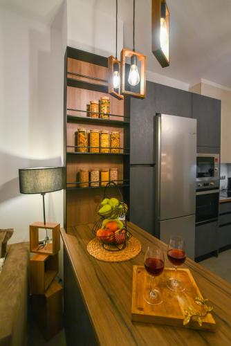 a kitchen with a table with a bowl of fruit and wine glasses at Mavromata's Cozy Apartment in Triovasálos
