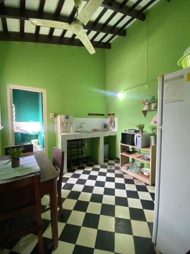 uma cozinha com paredes verdes e um piso em xadrez em Downtown Room em Assunção
