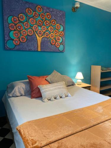 1 dormitorio con 1 cama con una pintura en la pared en Downtown Room en Asunción