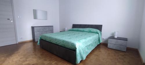una camera da letto con un letto con una coperta verde sopra di Alloggio TOBIA a Biella