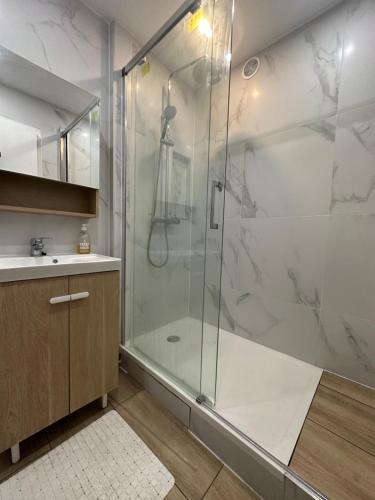 a bathroom with a shower with a glass shower stall at Chez Sony in Les Mureaux