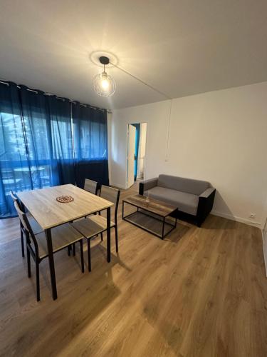 a living room with a table and a couch at Chez Sony in Les Mureaux