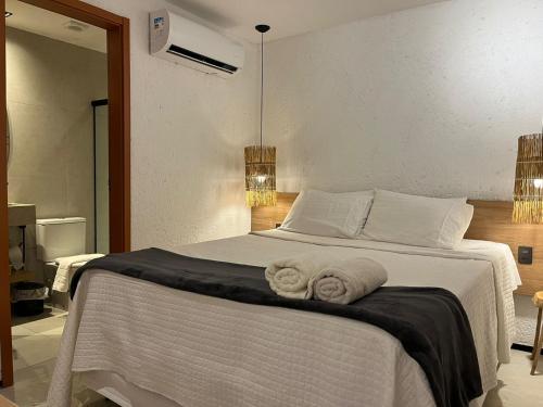 Un dormitorio con una cama blanca con toallas. en Villas Patacho Dreams, en Porto de Pedras