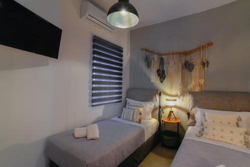 TriovasálosにあるMavromata's Cozy Apartmentのベッドルーム1室(ベッド2台、壁掛けテレビ付)