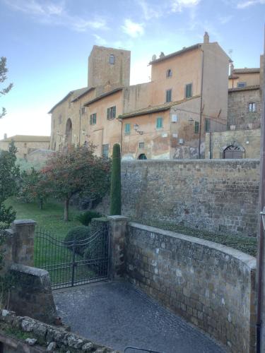 una pared de piedra con una puerta delante de un edificio en Il Bagolaro, en Tuscania