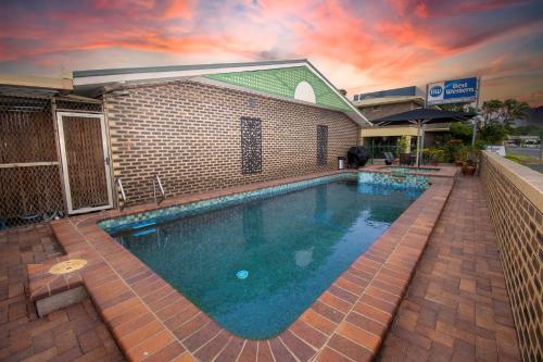 a large swimming pool in front of a building at Best Western Cattle City Motor Inn in Rockhampton