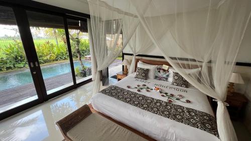 ein Schlafzimmer mit einem Himmelbett in der Unterkunft Bayad anyar - Ubud Bali in Ubud