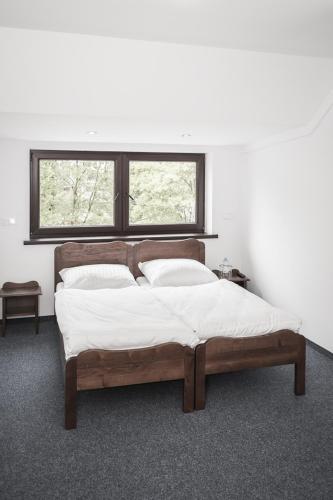 a bed in a white room with a window at W Starym Młynie in Milicz