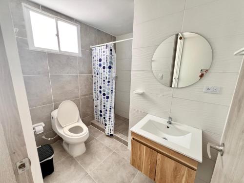 uma casa de banho com um WC, um lavatório e um espelho. em Caribbean Venture Apto 901- Rodadero, Santa Marta em Santa Marta