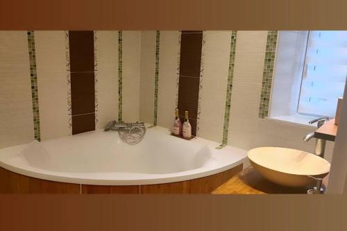 baño con bañera grande y ventana en Le Cocon du bord de l'Ill, en Illhaeusern