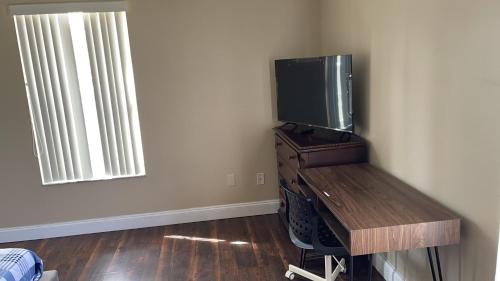 Cette chambre dispose d'une télévision au-dessus d'une table en bois. dans l'établissement Quite Private Bedroom0302next to Disney, à Davenport