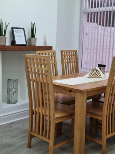 a wooden dining room table with four chairs and a table at Cosy modern house in Liverpool