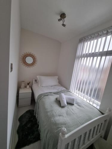 a bedroom with a bed and a large window at Cosy modern house in Liverpool