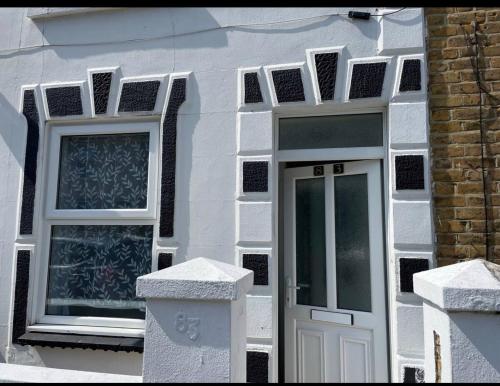 uma casa branca com uma porta e duas janelas em Samarlon Home Saxton em Gillingham