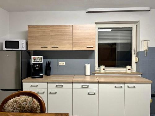 a kitchen with white cabinets and a window at Monteurhaus bei EnergyFreund in Hallstadt