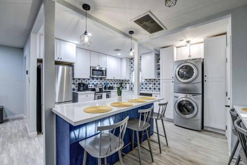 a kitchen with white cabinets and a blue island with bar stools at Modern Home-Downtown-3 Bedroom- King Bed in Phoenix