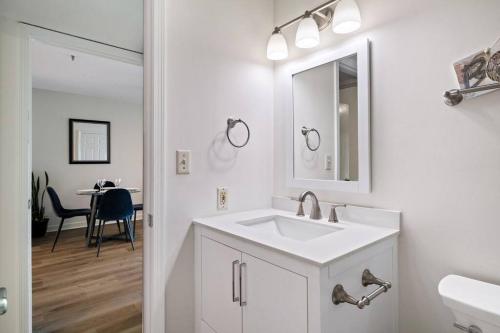 uma casa de banho branca com um lavatório e um espelho em Peaceful Treetop Condo - 2br/2ba em Hilton Head Island