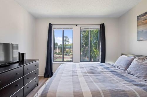 um quarto com uma cama e uma grande janela em Peaceful Treetop Condo - 2br/2ba em Hilton Head Island