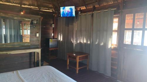 een slaapkamer met een bed en een tv aan de muur bij Experiencia Casa Blanca in Dzilam de Bravo