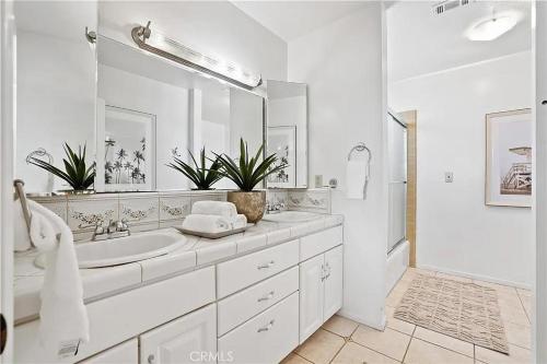 y baño blanco con lavabo y ducha. en Beachfront 3 Bedroom 3 Bath In Seal Beal, Ca, en Seal Beach