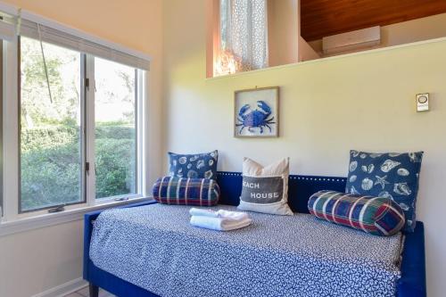 Cama azul en habitación con ventana en Lake House in Centerville with Private Water Access, en Barnstable