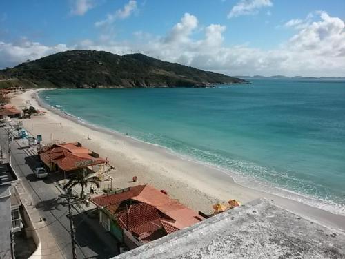 Una vista de una playa con edificios y el océano. en Arraial do Cabo, Loft Visão do Paraíso, en Arraial do Cabo