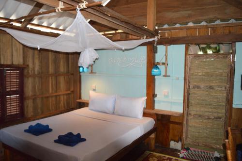 a bedroom with a bed with blue pillows on it at Palm Beach Bungalow Resort in Koh Rong Island