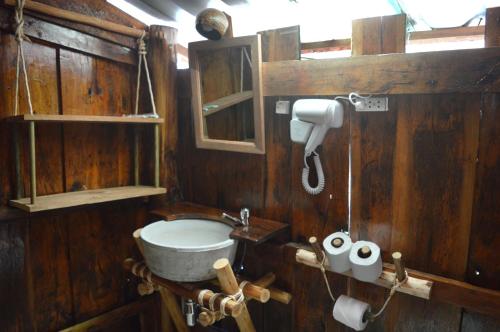 ein Holzbadezimmer mit einem Waschbecken und einem WC in der Unterkunft Palm Beach Bungalow Resort in Koh Rong