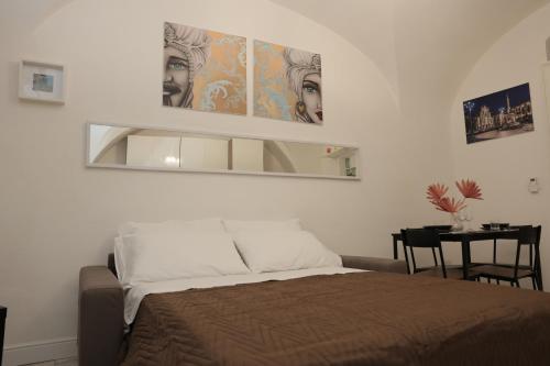 una camera da letto con un letto e uno specchio a parete di MOUSUITE a Catania