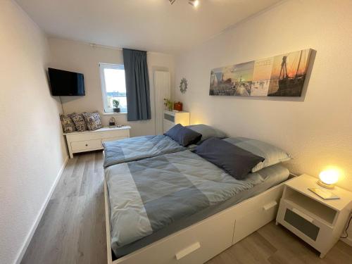 1 dormitorio pequeño con 1 cama y TV en Ferienwohnung-Maren, en Marienleuchte