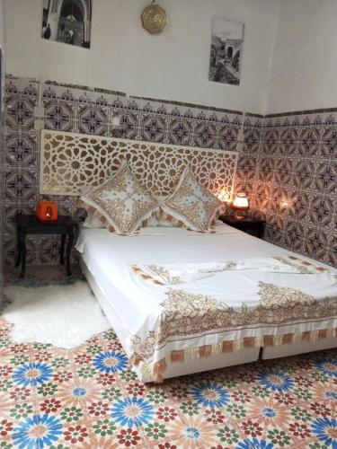 a bedroom with a bed with a patterned wall at Riad Amimi Fes in Fez