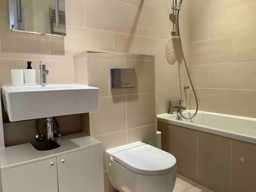 a bathroom with a toilet and a sink and a shower at Shad Thames by condokeeper in London