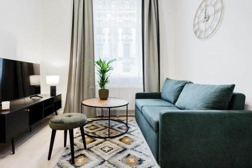 RIGAAPARTMENT ELIZABETES 22 Self-Service Aparthotel في ريغا: غرفة معيشة مع أريكة زرقاء وطاولة