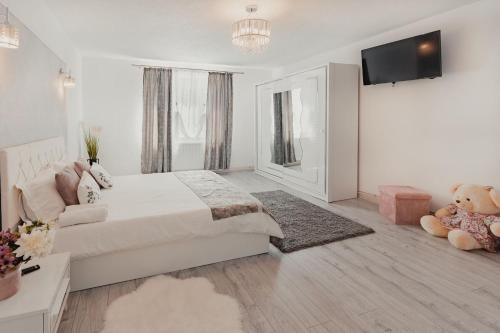 um quarto branco com uma cama grande e uma televisão em Central House em Sighisoara