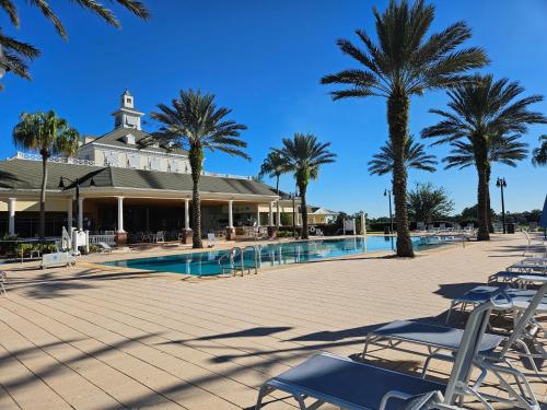 um resort com palmeiras e uma piscina em Endearing Private Bedroom in Shared House in Reunion Resort em Kissimmee