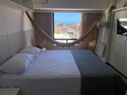 a bed with a hammock in a room with a window at Personal Residence in João Pessoa
