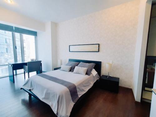 a bedroom with a bed and a desk in it at On Paseo de la Reforma, great location, luxurious, pool, gym, AC in Mexico City