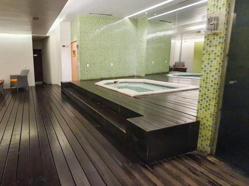 墨西哥城的住宿－On Paseo de la Reforma, great location, luxurious, pool, gym, AC，游泳池位于铺有木地板的客房中间