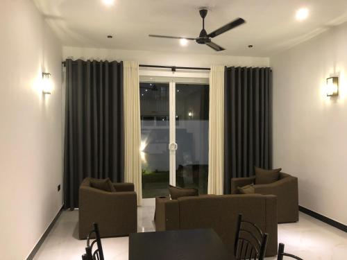 a living room with a table and chairs and a window at Luvi’s Villa in Galle