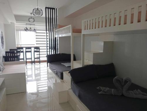 a bedroom with two bunk beds and a living room at WIND RESIDENCES SMDC TOWER 2 in Tagaytay