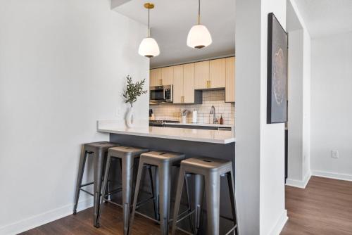 a kitchen with a counter and stools at a bar at UrbanDelight Crystal City Mins to DC Free Parking in Arlington