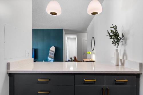 a kitchen with a white counter and a blue wall at UrbanDelight Crystal City Mins to DC Free Parking in Arlington