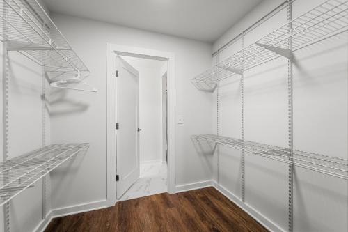 a walk in closet with white walls and shelves at UrbanDelight Crystal City Mins to DC Free Parking in Arlington