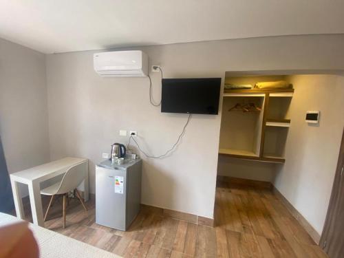 Habitación con escritorio y TV en la pared. en LOS LIRIOS en Puerto Iguazú