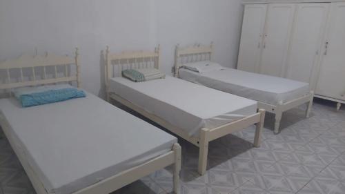 un gruppo di 3 posti letto in una camera di Casa DiTania Jatobá SE a Barra dos Coqueiros