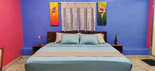 Schlafzimmer mit einem Bett mit blauen und roten Wänden in der Unterkunft Céntrico y Encantador Apartamento Angielin in Valladolid