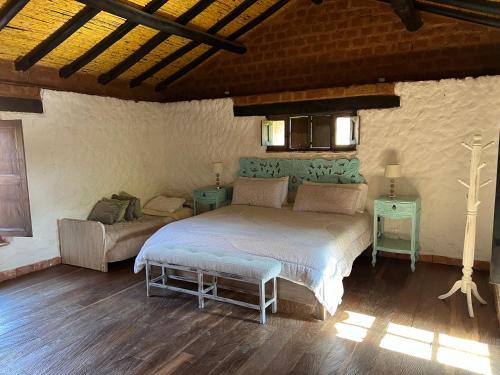 a bedroom with a bed and a couch at Casona Ananda in Firavitoba