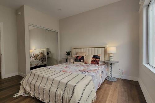 um quarto com uma cama grande e um espelho em Elegant Luxury 2BR Apt Near DTLA em Los Angeles