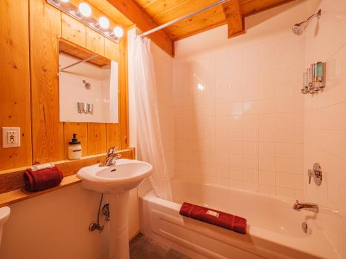 a bathroom with a sink and a toilet and a tub at The Cabins at Terrace Beach in Ucluelet