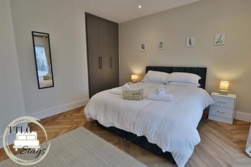 a bedroom with a large bed with two towels on it at Modern City Escape by TTLG Stays in Rickmansworth